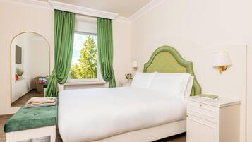 Ein Schlafzimmer mit einem Bett, einem Nachttisch, einem Spiegel und einem Fenster mit Vorhängen.