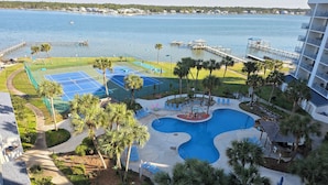 A resort with a swimming pool, tennis courts, and a dock extending into a lake. - 1BR/1B~sleeps 4~Boat Parking~Pool~Pickleball! (Gulf Shores)