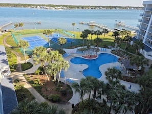 A resort with a swimming pool, tennis courts, and a dock extending into a lake. - Late Cancellation Sale ~ July 5th-11th! (Gulf Shores)
