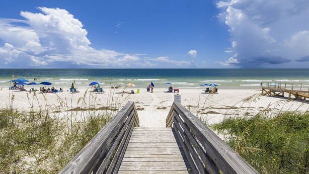 A wooden boardwalk leading to a beach with umbrellas and people. - 1BR/1B~sleeps 4~Boat Parking~Pool~Pickleball! (Gulf Shores)