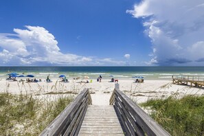 A wooden boardwalk leading to a beach with umbrellas and people. - Halloween Sale 1BR/1B~Boat Parking~Pool~Pickleball (Gulf Shores)