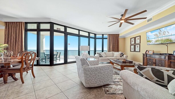 A spacious living area with a balcony, a dining set, and a seating arrangement. - 3rd Floor!! Parking Level!  Avoid the Elevators!! Lazy River!! (Orange Beach)