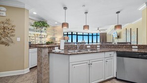 A modern kitchen with granite countertops, white cabinetry, and pendant lighting. - 3rd Floor!! Parking Level!  Avoid the Elevators!! Lazy River!! (Orange Beach)