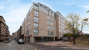 Een hotel met meerdere verdiepingen, met een modern design, een entree op de begane grond en een zichtbaar restaurantbord.