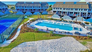 A large swimming pool surrounded by a fenced area, with multiple buildings in the background. - Beautiful, Pet Friendly, Waterfront Townhome at San De Luna #3! (Pensacola Beach)