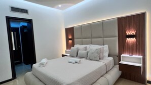 Een moderne slaapkamer met een groot bed, ingebouwde verlichting en een minimalistisch design.