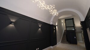 En modern inredning med en geometrisk formgiven lampa och en trappa.