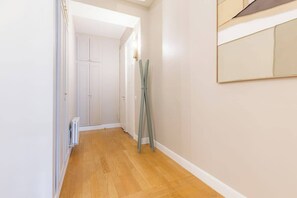 Ein Korridor mit Holzboden, einem Heizkörper und einer Tür zu einem Zimmer.