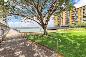 A pathway leading to a building with a view of a body of water. - Waterfront Opal Suite: 1 Bed Apt, Water Views (Darwin)