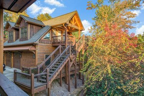 Eine Blockhütte mit Balkon und einer Treppe, die zum oberen Stockwerk führt.
