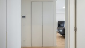 A modern room with a white wardrobe, a flat-screen TV, and a wooden floor. - Modern Lisbon W Balcony by Homing (Lisbon)