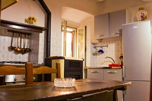 A kitchen with a wooden table, a refrigerator, and a sink.