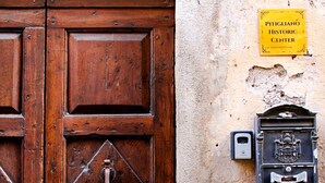 Una puerta de madera con un candado metálico y un letrero amarillo que indica un centro histórico.