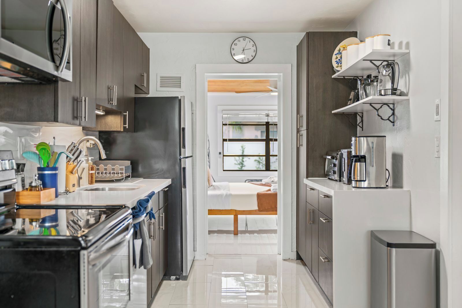 A modern kitchen with stainless steel appliances, a built-in oven, and a coffee machine.