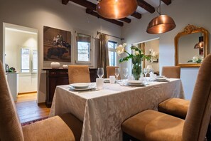 A dining area with a table set for four, a painting on the wall, and a mirror with an ornate frame. - Two bedrooms apartment with Terrace in Castello (Venezia)