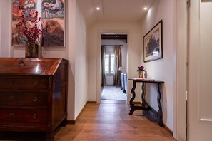 A hallway with a wooden dresser, a console table, and artwork on the walls. - Ca' Barbarina 1 (Venezia)