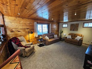 A cozy living room with wooden walls and ceiling, two sofas, a coffee table, and a floor lamp. - 3BR Entire Home-Dog Friendly- Near DIA & Golf Course - Hot Tub (Denver)