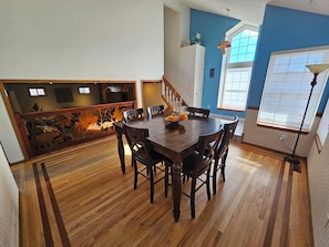 A dining area with a wooden table and chairs, a decorative wall, and a staircase. - 3BR Entire Home-Dog Friendly- Near DIA & Golf Course - Hot Tub (Denver)