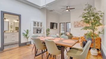 A dining area with a wooden table, chairs, and a ceiling fan.