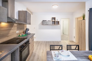 Une cuisine moderne dotée d’un îlot central, de meubles de rangement intégrés et d’un coin repas avec une table et des chaises.
