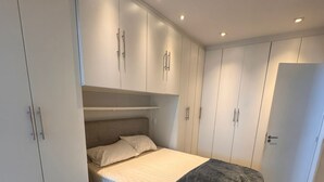 Ein Schlafzimmer mit Bett, Einbauschrank und Tür.