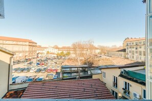 A view from a balcony overlooking a parking lot and buildings. - GuestHost - A cozy 40 sq m apartment that comfortably accommodates two people, located on the third floor of a period building with an elevator. The apartment is centrally located in the Quadrilatero neighborhood, just steps from Piazza della Consolata a (Turin)