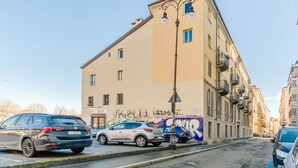 A street with parked cars, a building with graffiti, and a street lamp. - GuestHost - A cozy 40 sq m apartment that comfortably accommodates two people, located on the third floor of a period building with an elevator. The apartment is centrally located in the Quadrilatero neighborhood, just steps from Piazza della Consolata a (Turin)