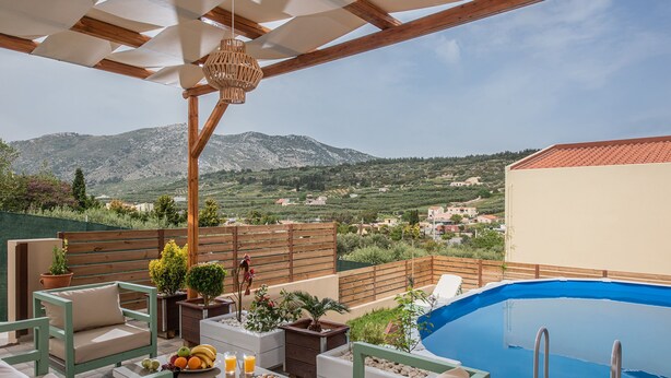 A rooftop terrace with a swimming pool, outdoor furniture, and a view of the surrounding landscape. - Iris Villa 3 (Archanes-Asterousia)