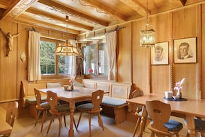 Una sala da pranzo in legno con un tavolo grande, panche e sedie.