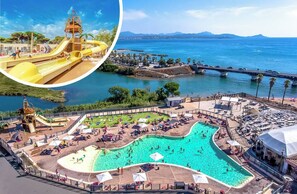 A large outdoor swimming pool with a slide, surrounded by sun loungers and umbrellas, with a view of the sea and a bridge in the background. - Mobile home 36 m² - 2 bedrooms - Saint-Aygulf (Fréjus) (Fréjus)