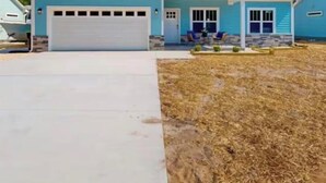 A single-story house with a garage, a front porch, and a well-maintained lawn. - Relaxing 3-bedroom house close to
Holden Beach! (Supply)