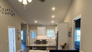 A spacious living room with a ceiling fan, a patterned rug, and a couch with decorative pillows. - Relaxing 3-bedroom house close to
Holden Beach! (Supply)