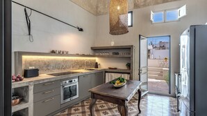 Una cucina moderna con una grande isola, forno integrato e un tavolo da pranzo.