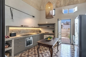 Una cucina moderna con una grande isola, forno integrato e un tavolo da pranzo.