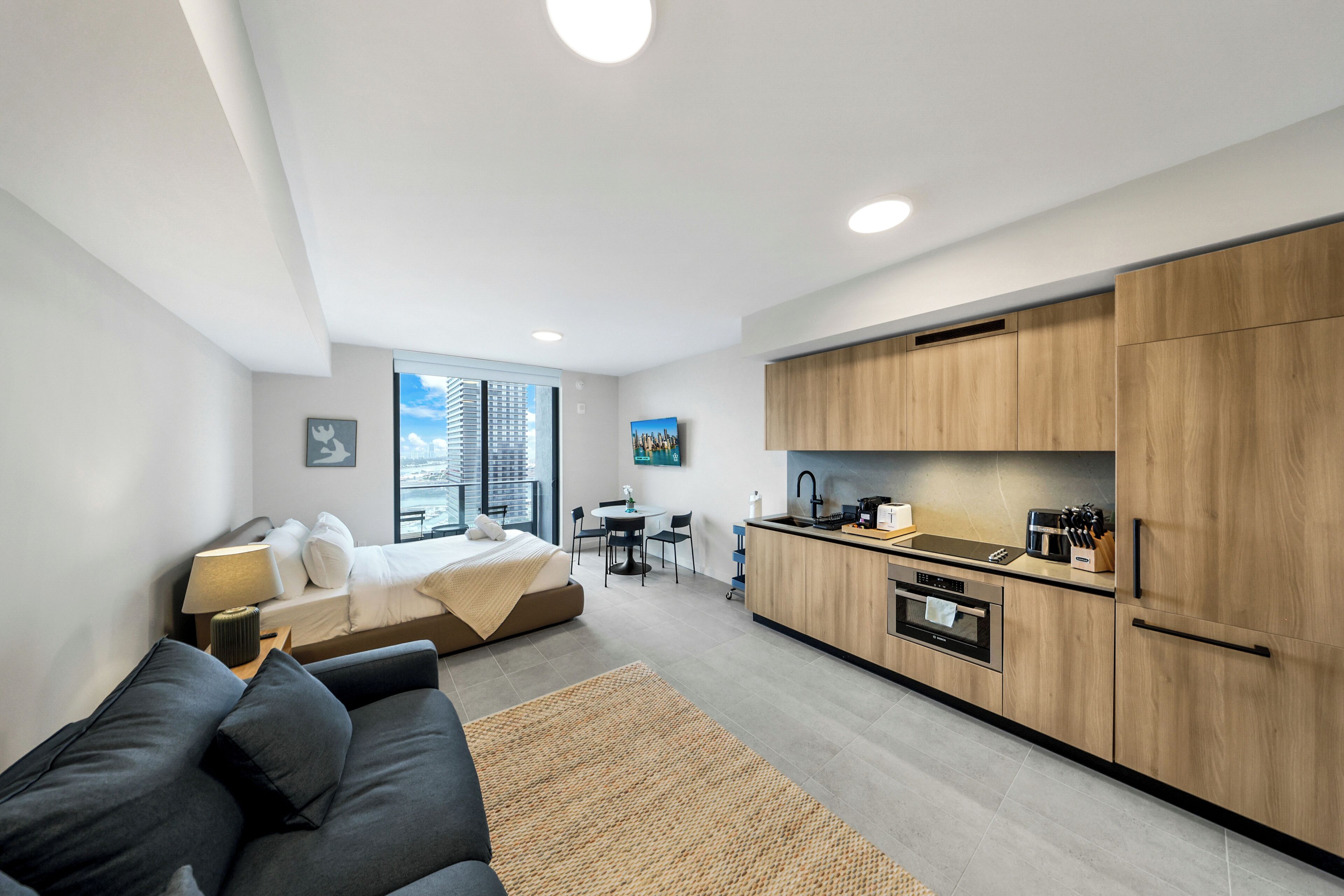 Un appartement moderne comprenant un coin cuisine, un espace repas, un lit et un salon.