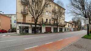 Une rue bordée d’immeubles, avec une pharmacie et un panneau indiquant qu’il est interdit de se garer.