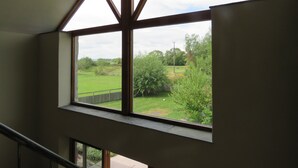 Una stanza con un'ampia finestra a lucernario che si affaccia su un paesaggio verde.