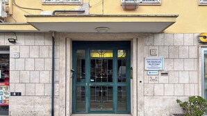 Un bâtiment avec une porte verte, une enseigne indiquant « Studio Dentistico », et une petite plante en pot.