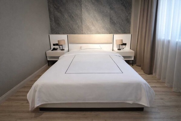 A modern hotel room with a large bed, two bedside tables with lamps, a neutral-toned headboard, and sheer curtains. - ANEMON GRAND ŞANLIURFA (Sanliurfa)