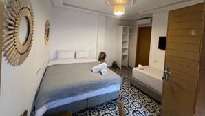 A hotel room with a bed, a bedside table, a chair, a wardrobe, and a bathroom. - RIAD HOUCINE (Marrakech)