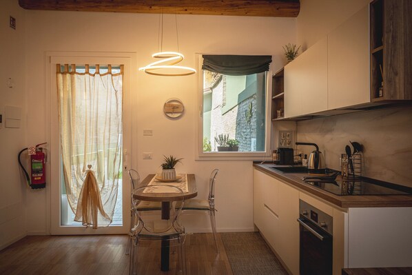A modern kitchen with a dining area, a window with a view, and a fire extinguisher on the wall.