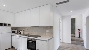 A modern kitchen with white cabinetry, a built-in oven, a microwave, and a sink. - Holiday Home 'Casa Da Oliveira' with Shared Pool, Wi-Fi and Air Conditioning (Dornelas)