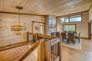 A wooden interior with a staircase, dining area, and large windows. - Heated Pool, Spa, Mountain Views, 5 Kings, Close to Downtown (Blue Ridge)
