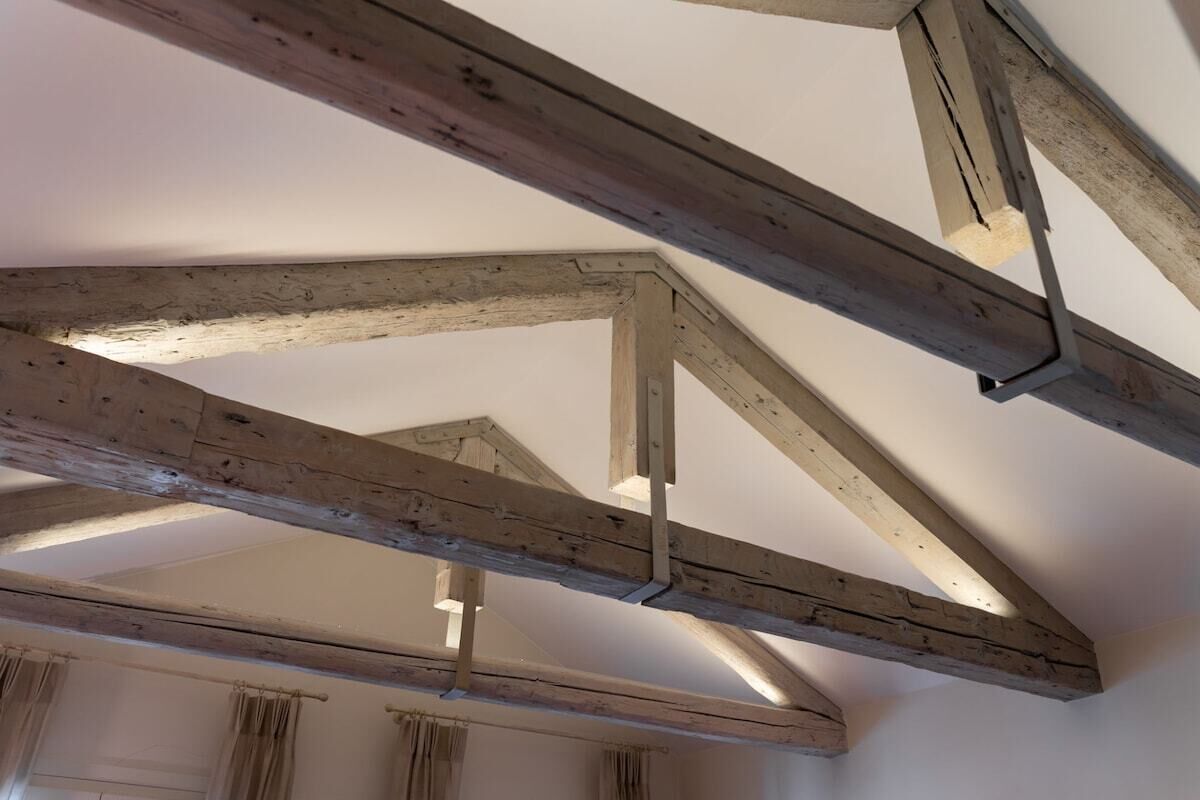 A room with exposed wooden beams and a sloped ceiling.
