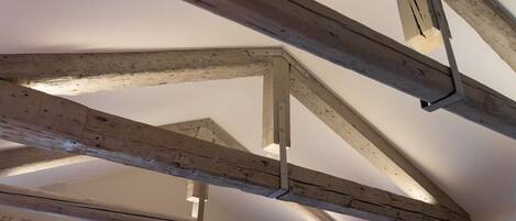 A room with exposed wooden beams and a sloped ceiling.