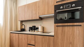Eine moderne Küche mit Holzausstattung, einem schwarzen Backofen und einem Spülbecken aus Edelstahl.