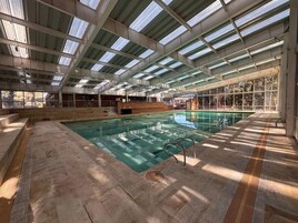 Una piscina techada, sillones reclinables de piscina