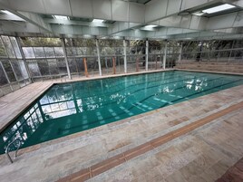 Una piscina techada, sillones reclinables de piscina