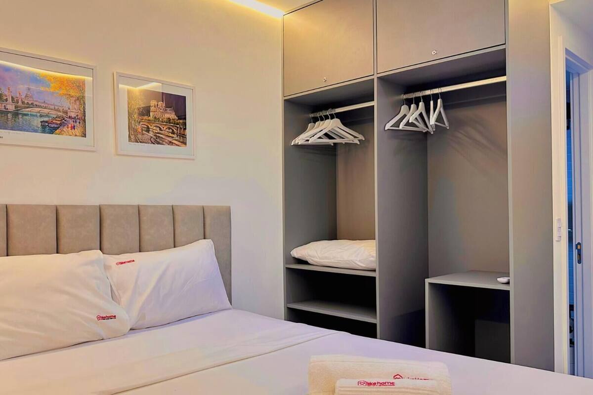 Une chambre d’hôtel avec un lit, une armoire et deux tableaux encadrés au mur.