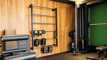A gym with a pull-up bar, weight racks, and exercise equipment.